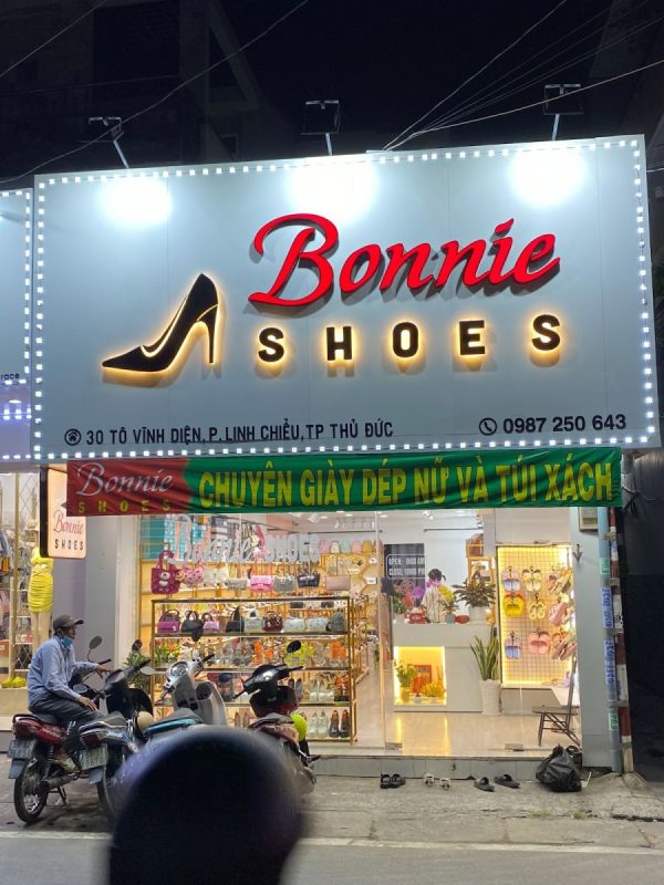 Chính diện bảng hiệu shop giày dép Bonnie buổi tối